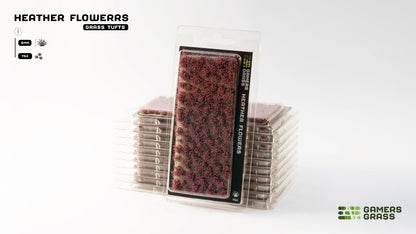 Blister pack of purple heather flower grass tufts for miniature scenery, with a stack of identical packs behind it