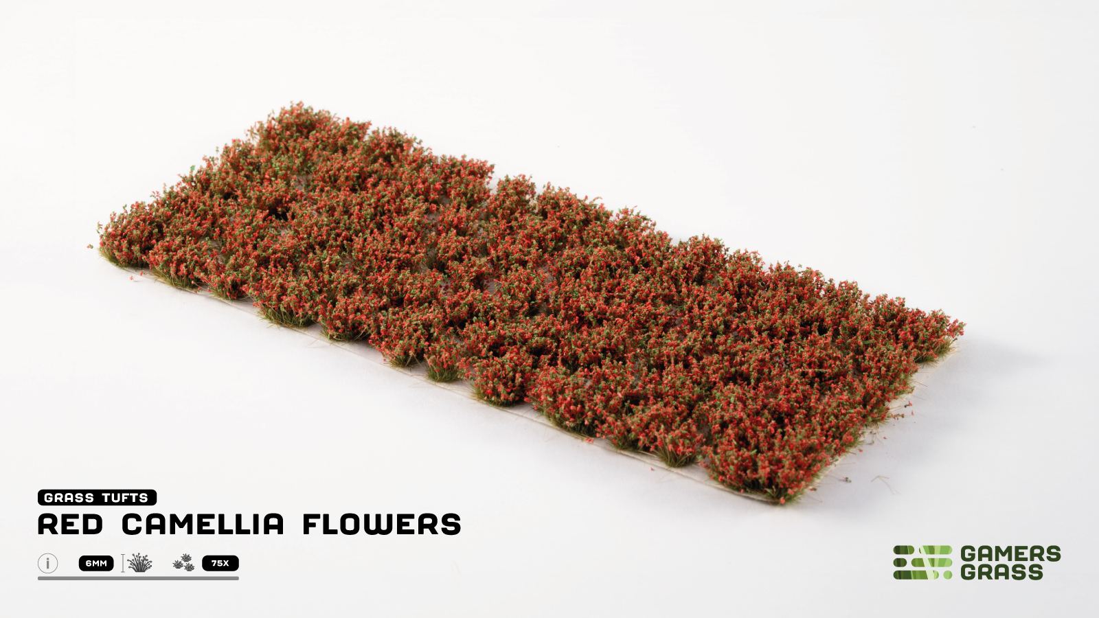 Miniature grass tufts with vibrant red camellia flowers and green bases, arranged on a white surface