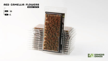 Stacked clear packages of Gamers Grass "Red Camellia Flowers" grass tufts, showing numerous small red-brown clusters