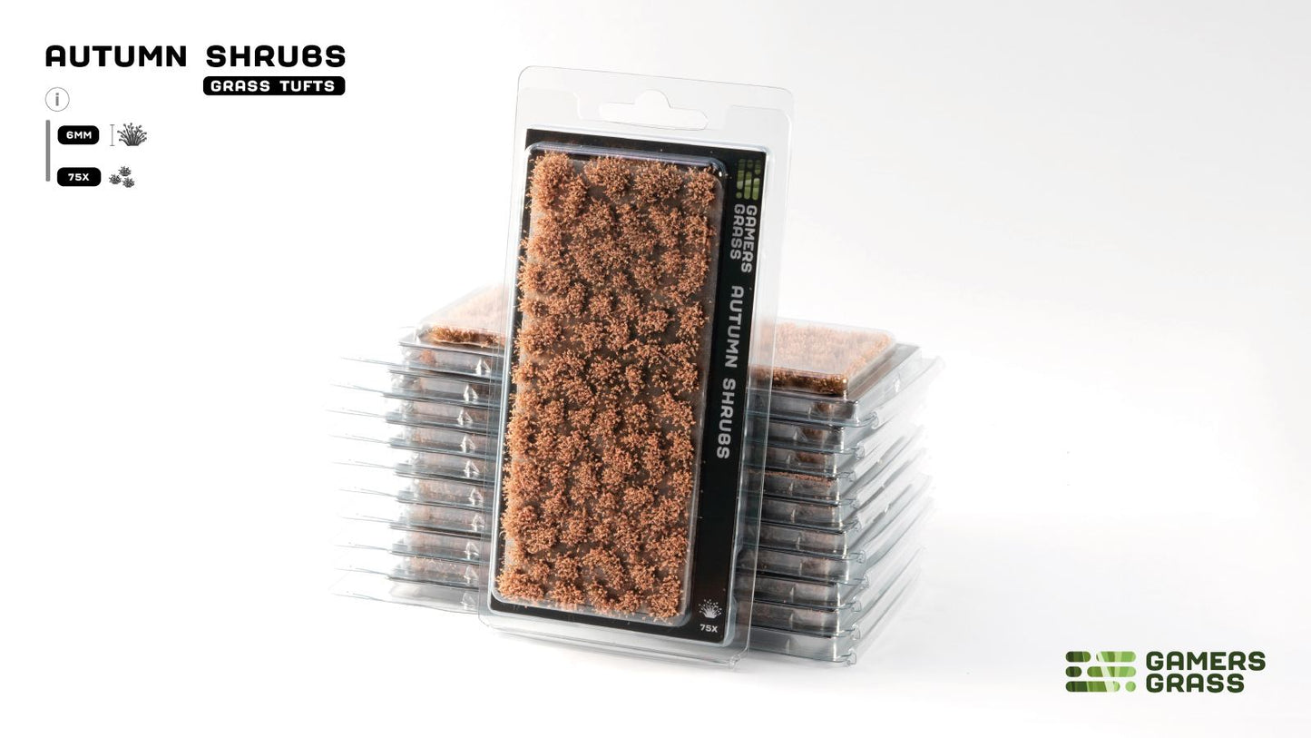 A blister pack of brown 'Gamers Grass Autumn Shrubs' (grass tufts), with more packs stacked behind