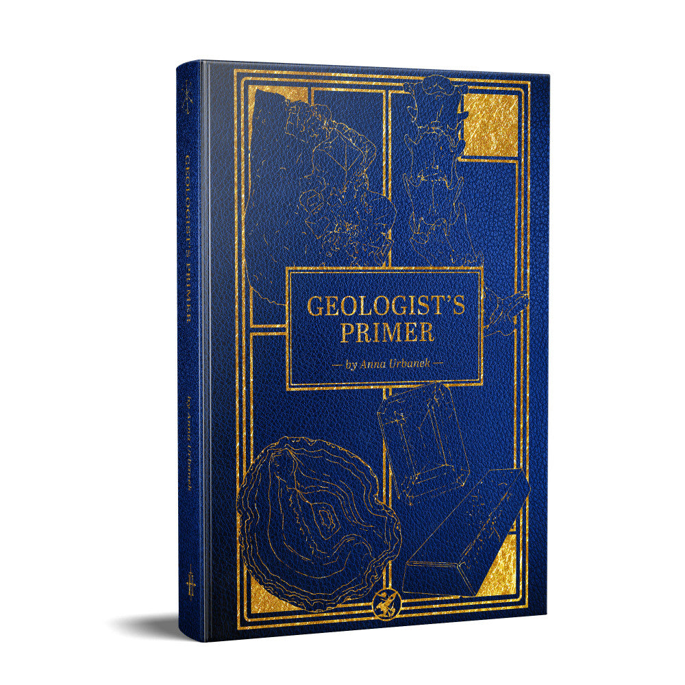 Blue book, "Geologist's Primer" by Anna Urbanek, with gold line art depicting rocks, crystals, and geological elements