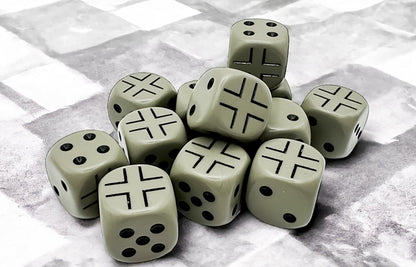 A pile of dark grey dice on a textured grey background. Some show pips, others black Iron Crosses