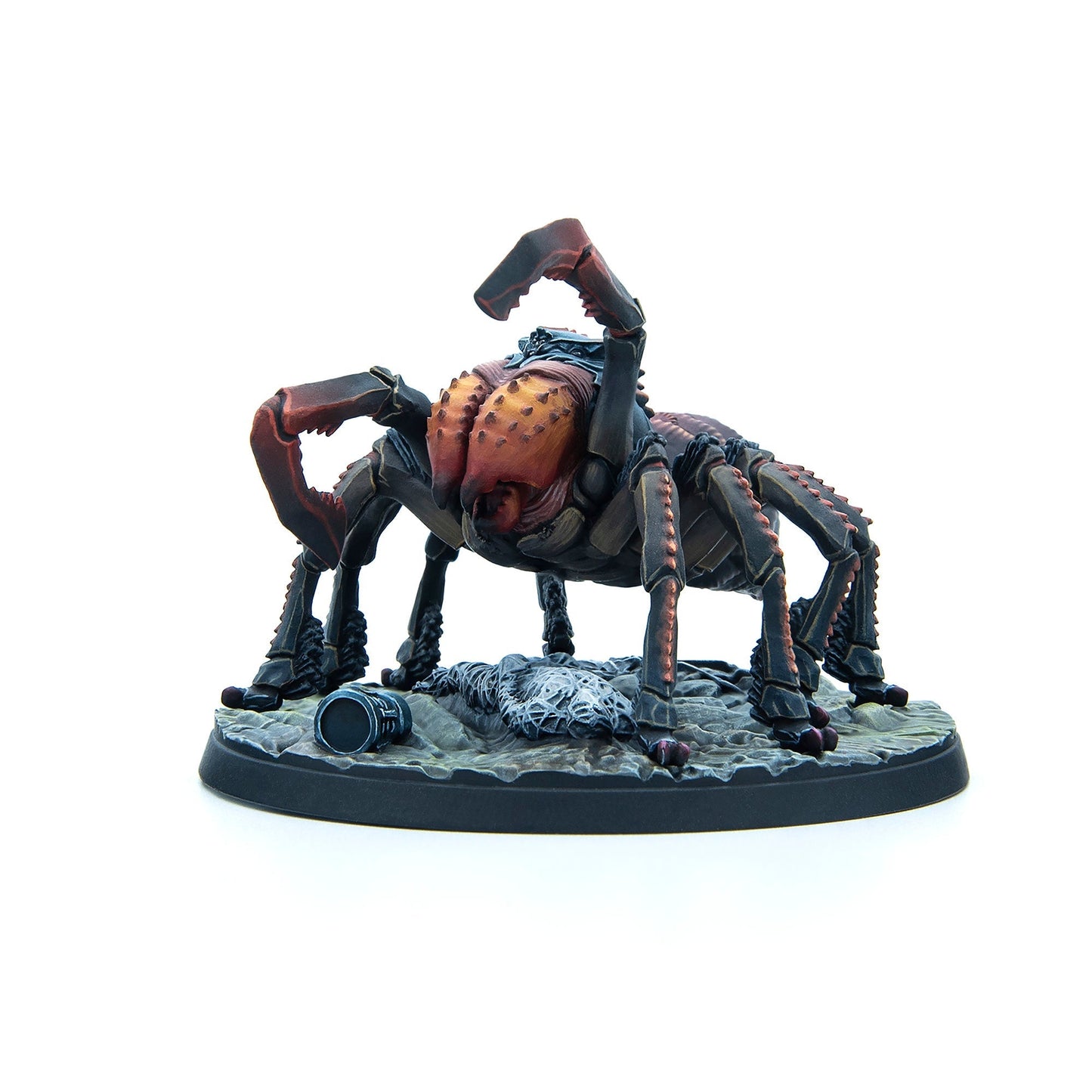 A dark fantasy miniature of a spider-like monster with raised red pincers, standing on a rocky base with a skeleton