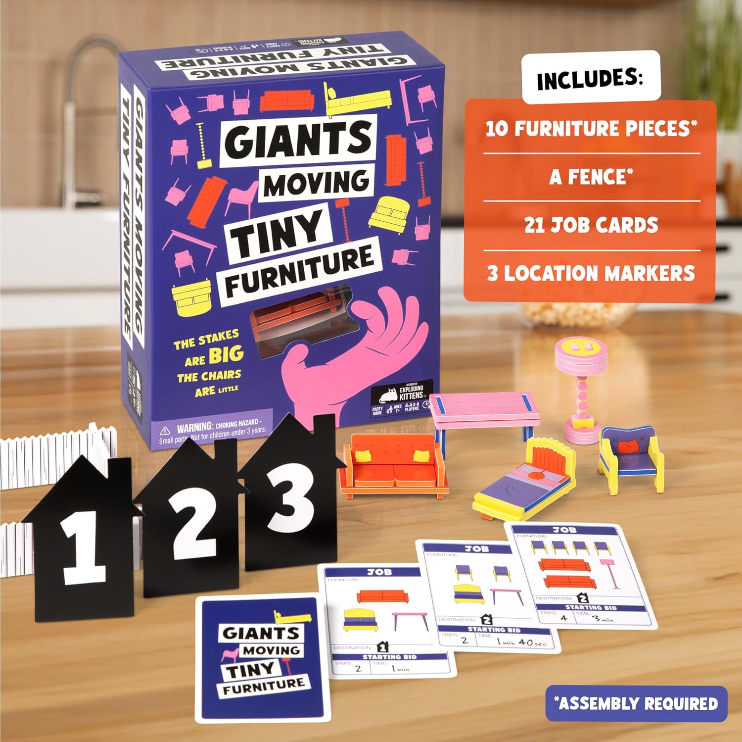 Giants Moving Tiny Furniture board game displayed with its box, miniature furniture, numbered house markers, fence, and job cards