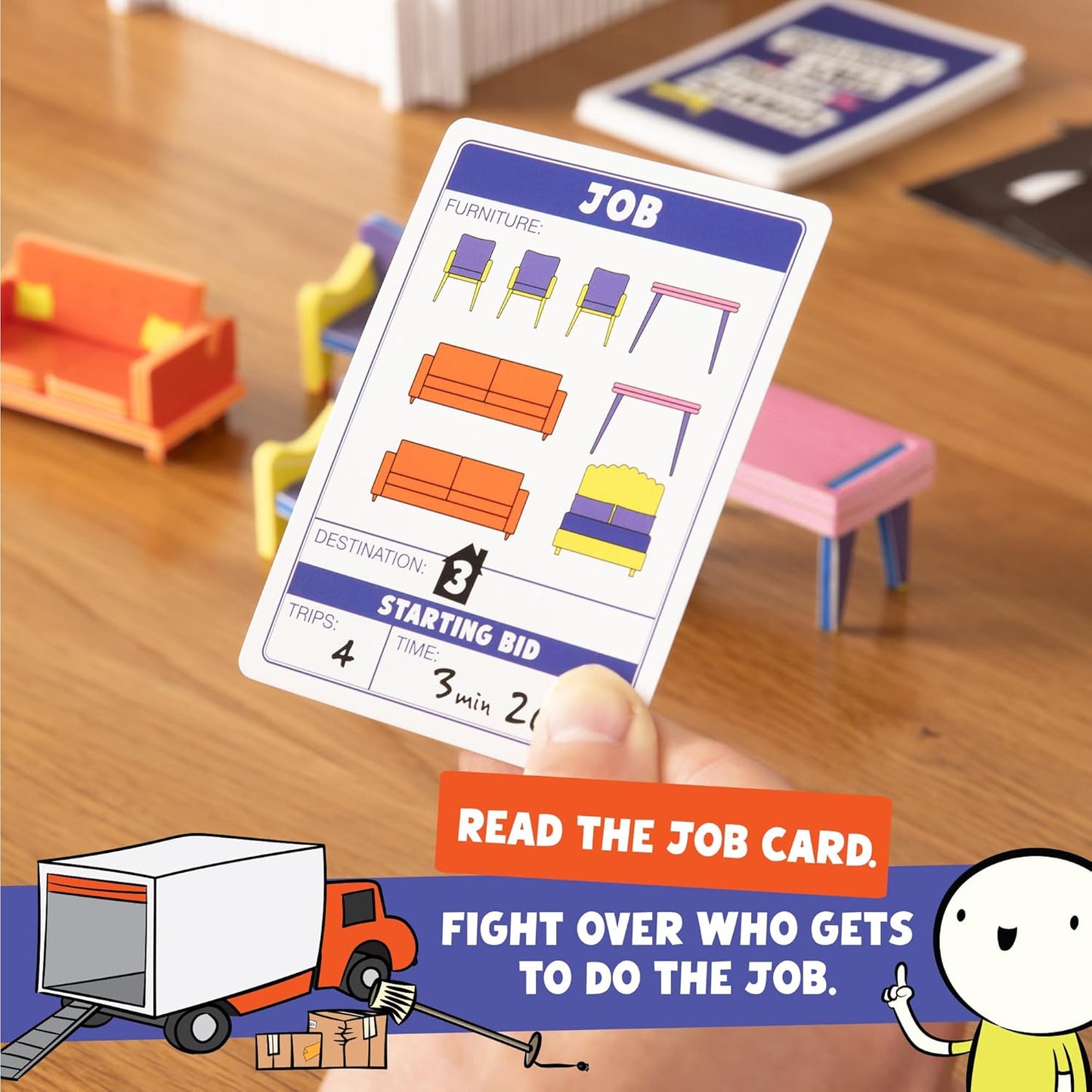 Hand holding a 'JOB' game card displaying furniture, destination 3, 4 trips, and a starting bid, above miniature game furniture