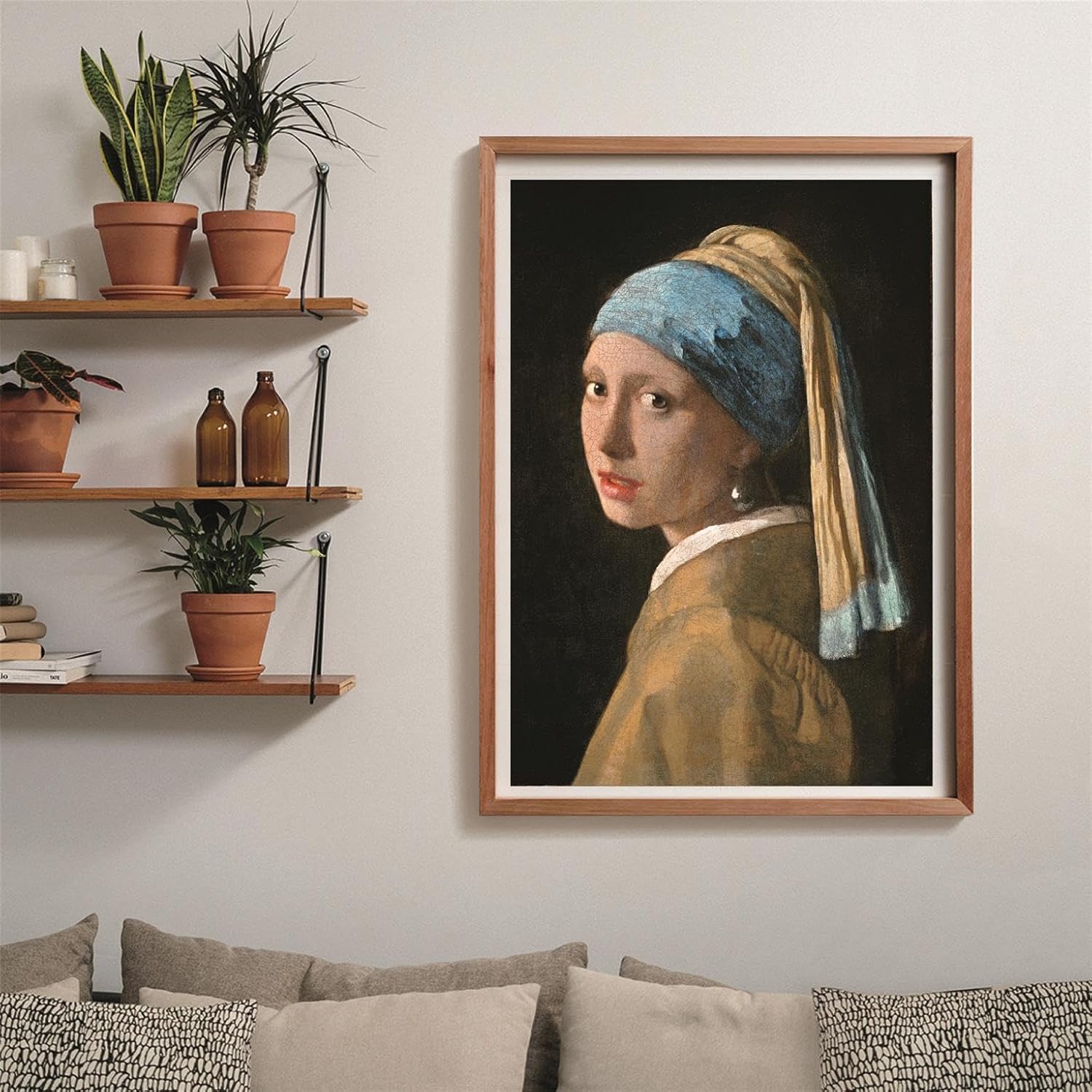 Framed "Girl with a Pearl Earring" painting by Vermeer hangs on a wall, with potted plants on shelves and a sofa below
