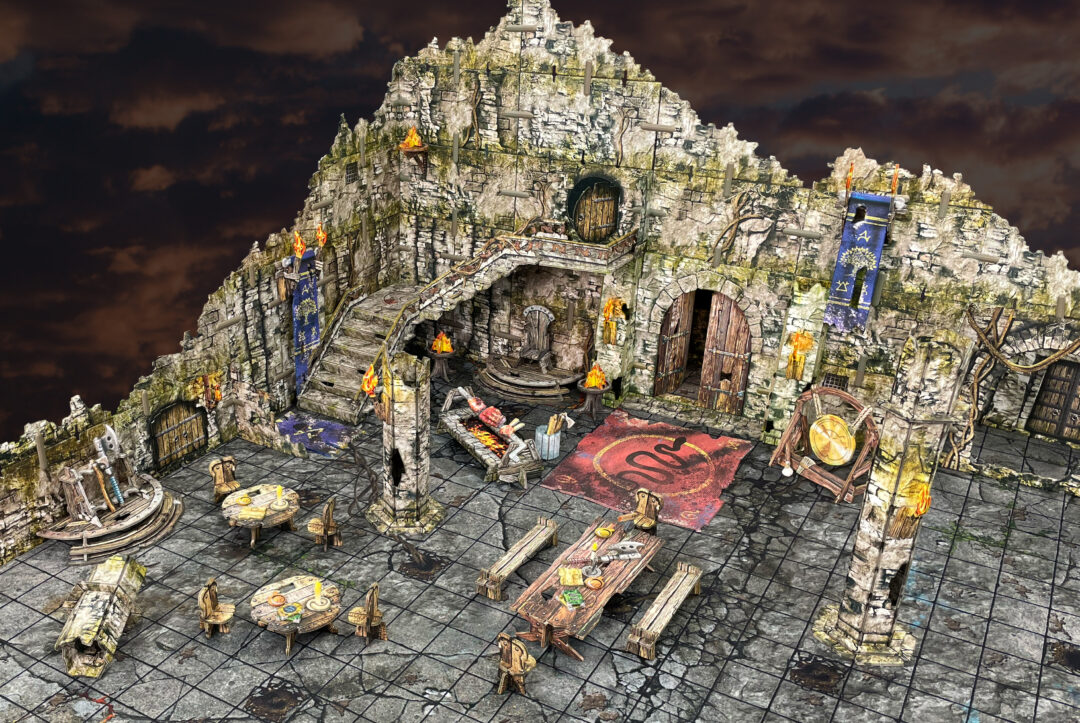 An intricate multi-level stone fortress tabletop terrain, featuring stairs, doors, tables and lit torches under dark clouds
