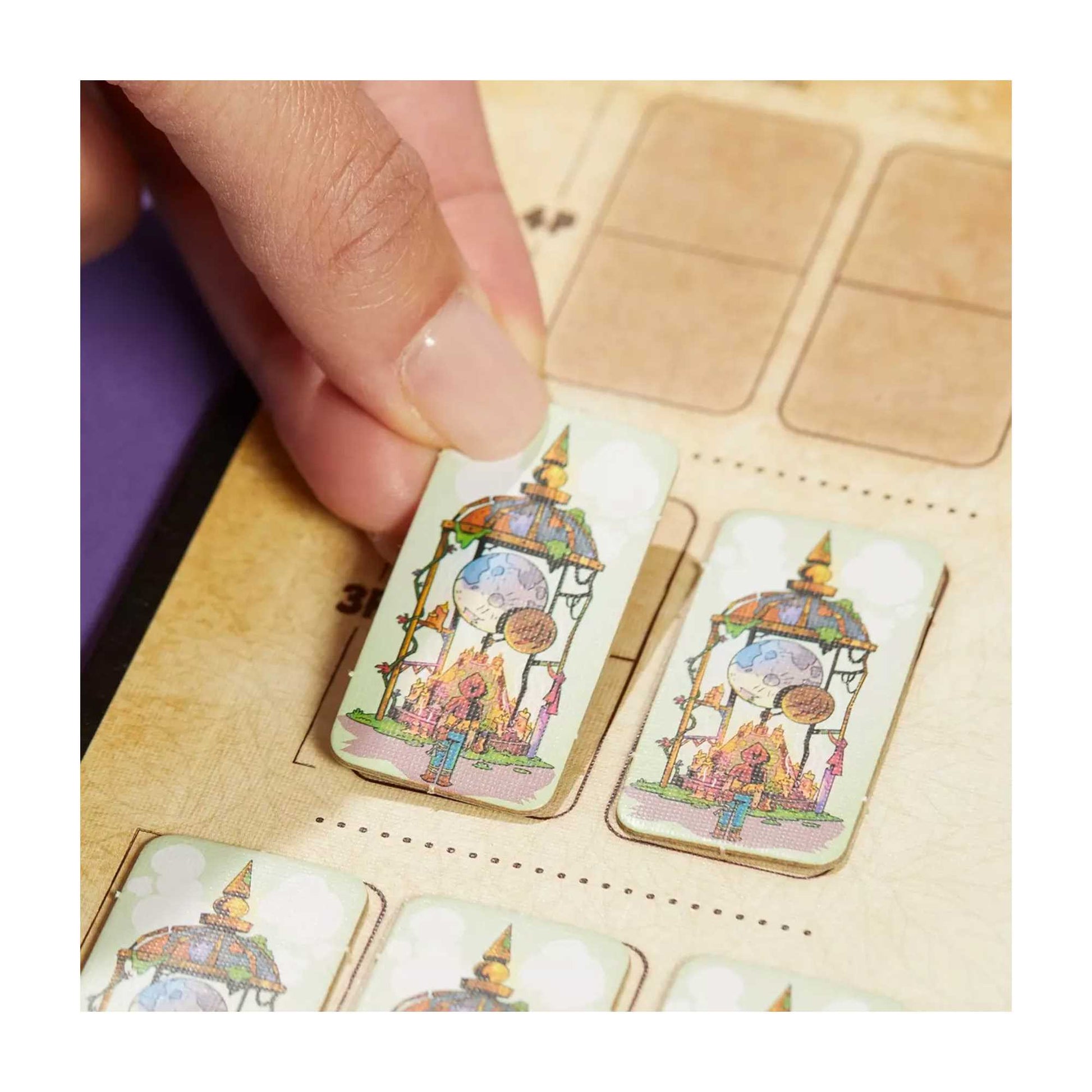Hand places a tile with fantasy art of a moon and pavilion onto a slot in a wooden board game