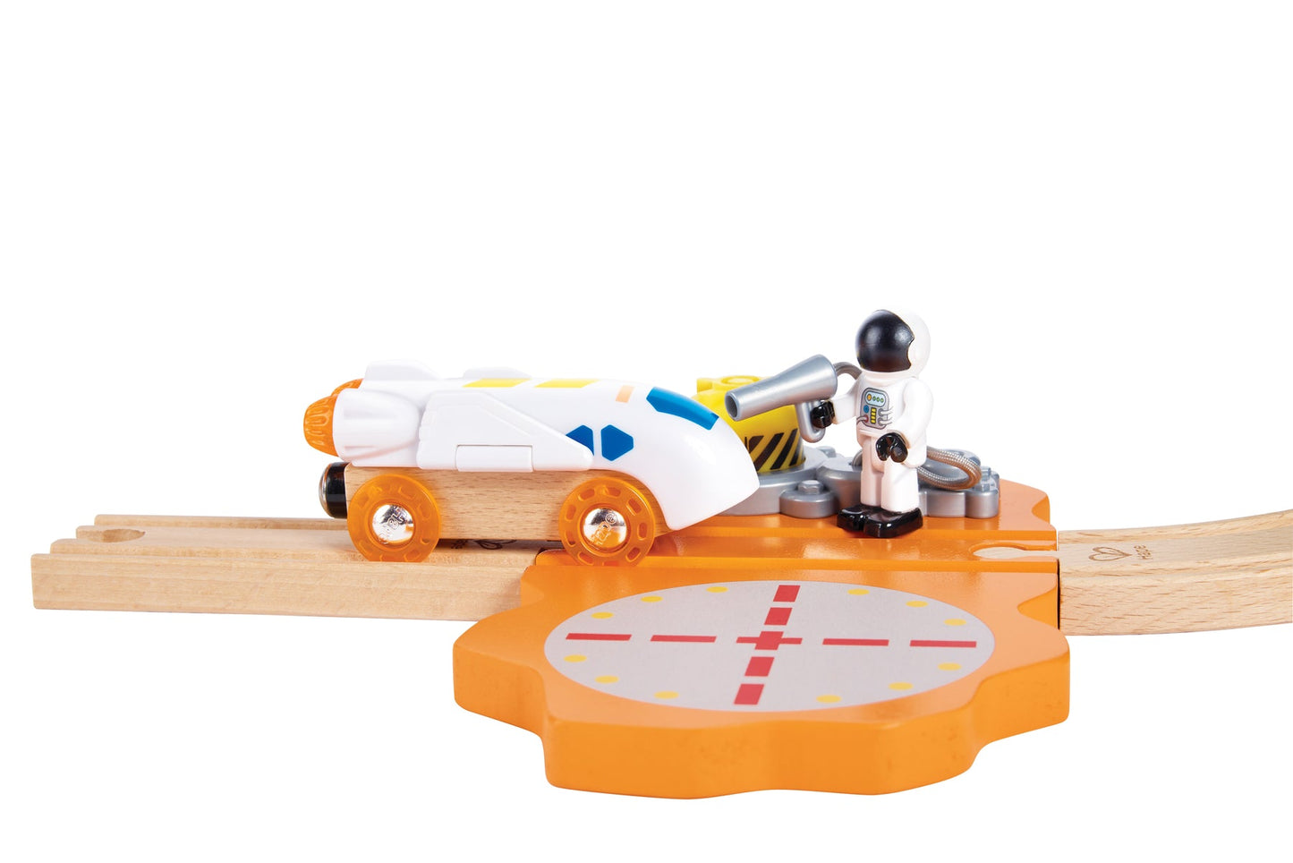 Astronaut toy figure refuels a white wooden rocket train car at an orange maintenance station