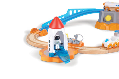 Toy astronaut in a white rocket on a launchpad, connected to a wooden train track set