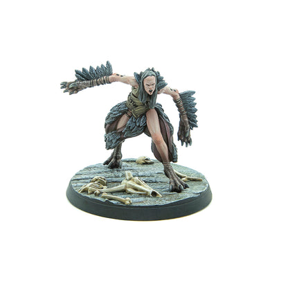 Screaming harpy miniature with outstretched, feathered arms and taloned feet, standing on a base with skulls
