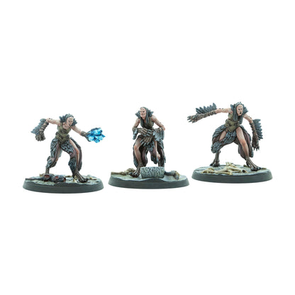 Three gaunt female miniatures in feathered attire - one casts a blue crystal spell, one crouches, one lunges snarling