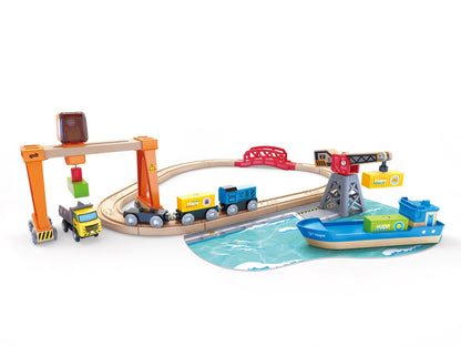 Hape wooden Lift & Load Harbour toy set featuring a train track, ship, truck, and two cranes loading containers