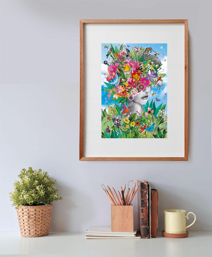 A framed collage shows a woman's face with an elaborate crown of vibrant flowers, birds, and jungle animals under a blue sky.