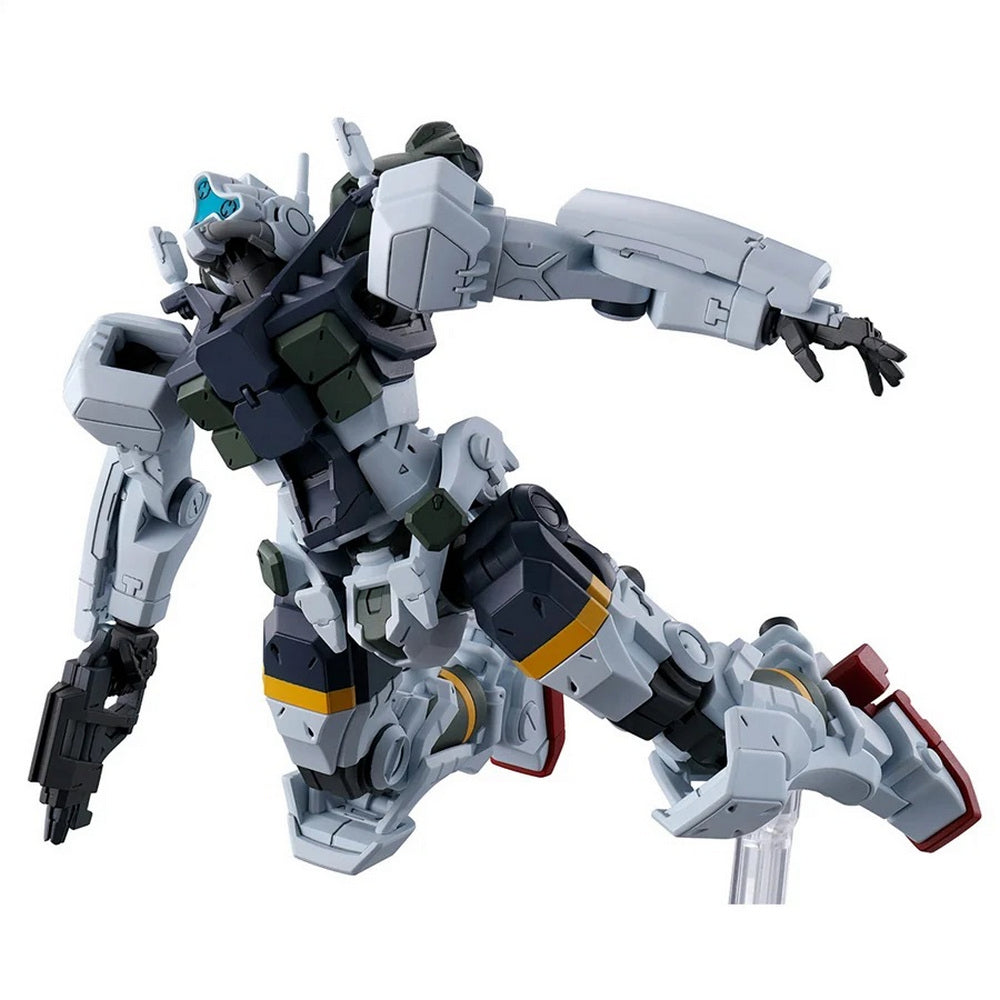 A gray and black mecha model, holding a gun, is dynamically posed as if flying on a clear stand
