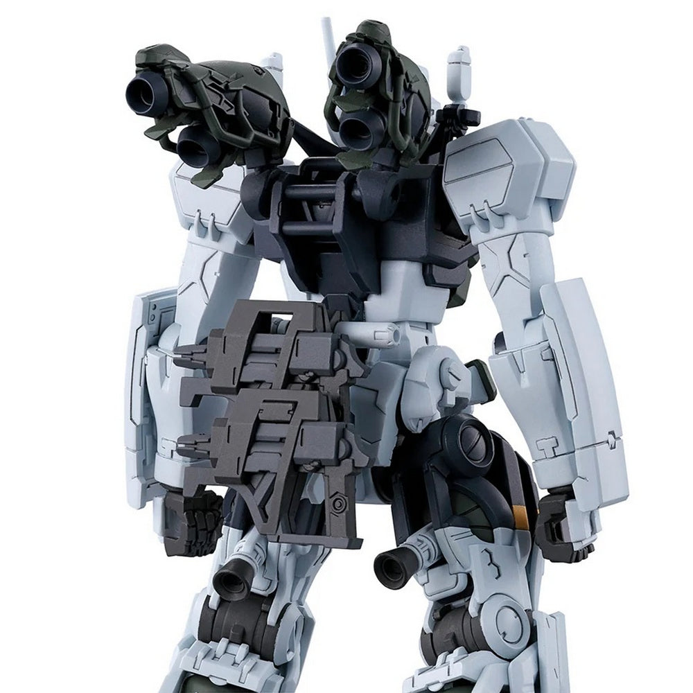 A light gray mechanical model, viewed from the back, heavily armed with multi-barreled shoulder weapons and a detailed dark gray backpack