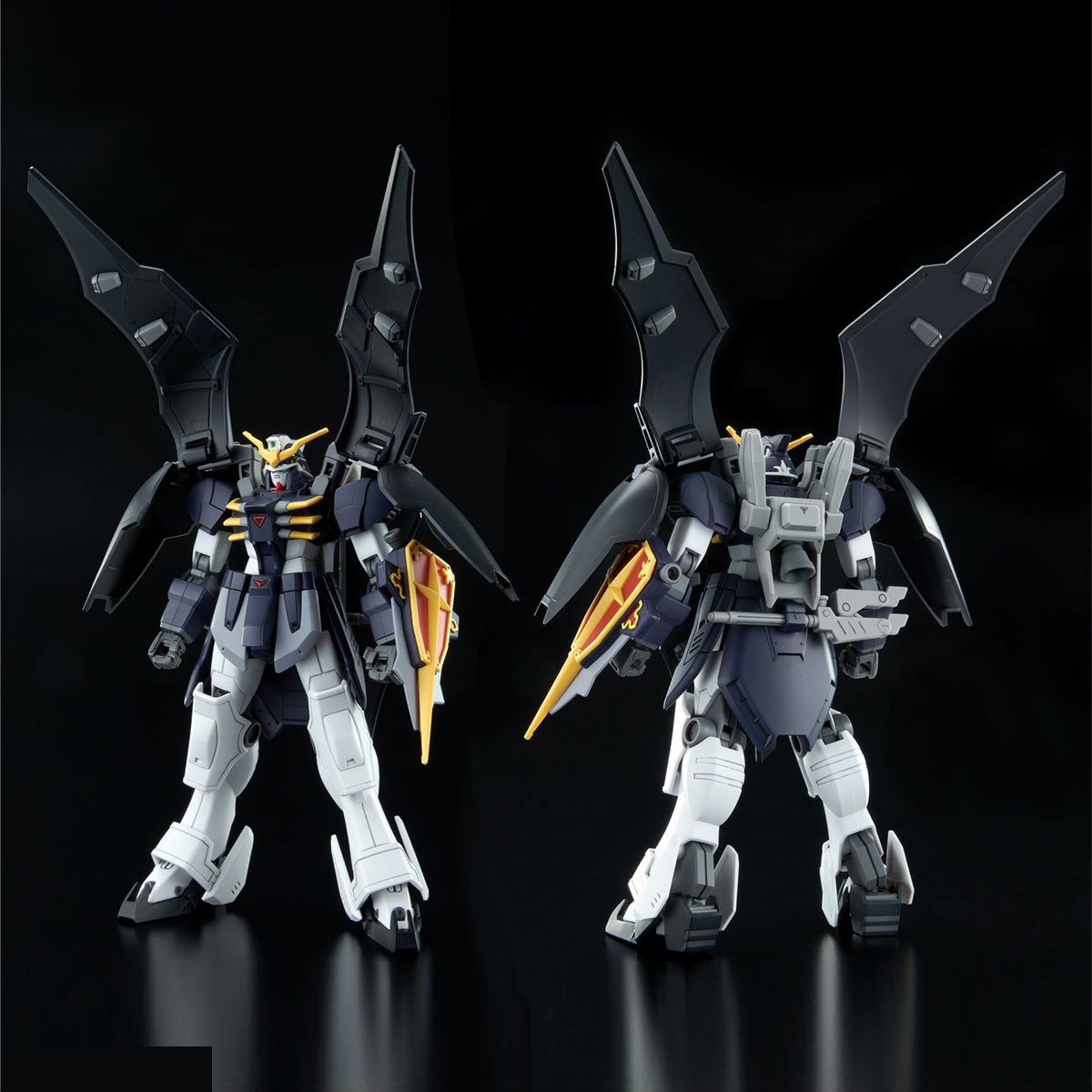 Front and back views of a dark blue & white winged Gundam model with large black wings and a blade shield