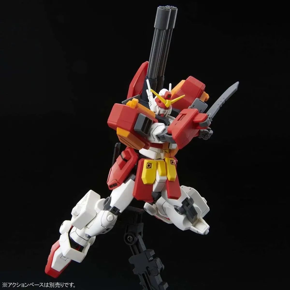 A red, white, and yellow Gundam model in an action pose, wielding a gray knife and featuring a shoulder cannon