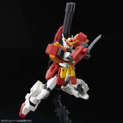 A red, white, and yellow Gundam model in an action pose, wielding a gray knife and featuring a shoulder cannon