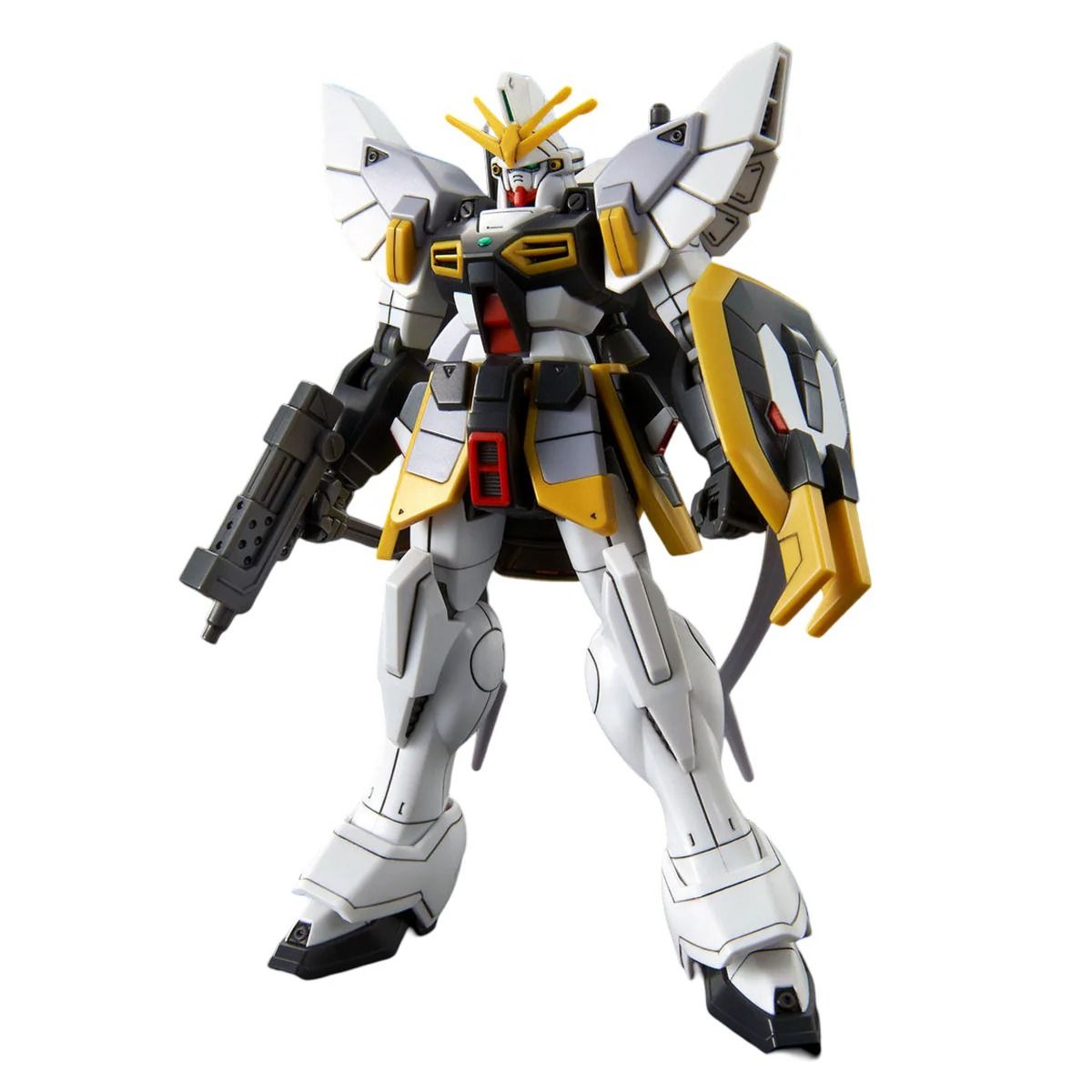 White, grey, and yellow Wing Gundam model standing, holding a rifle and shield