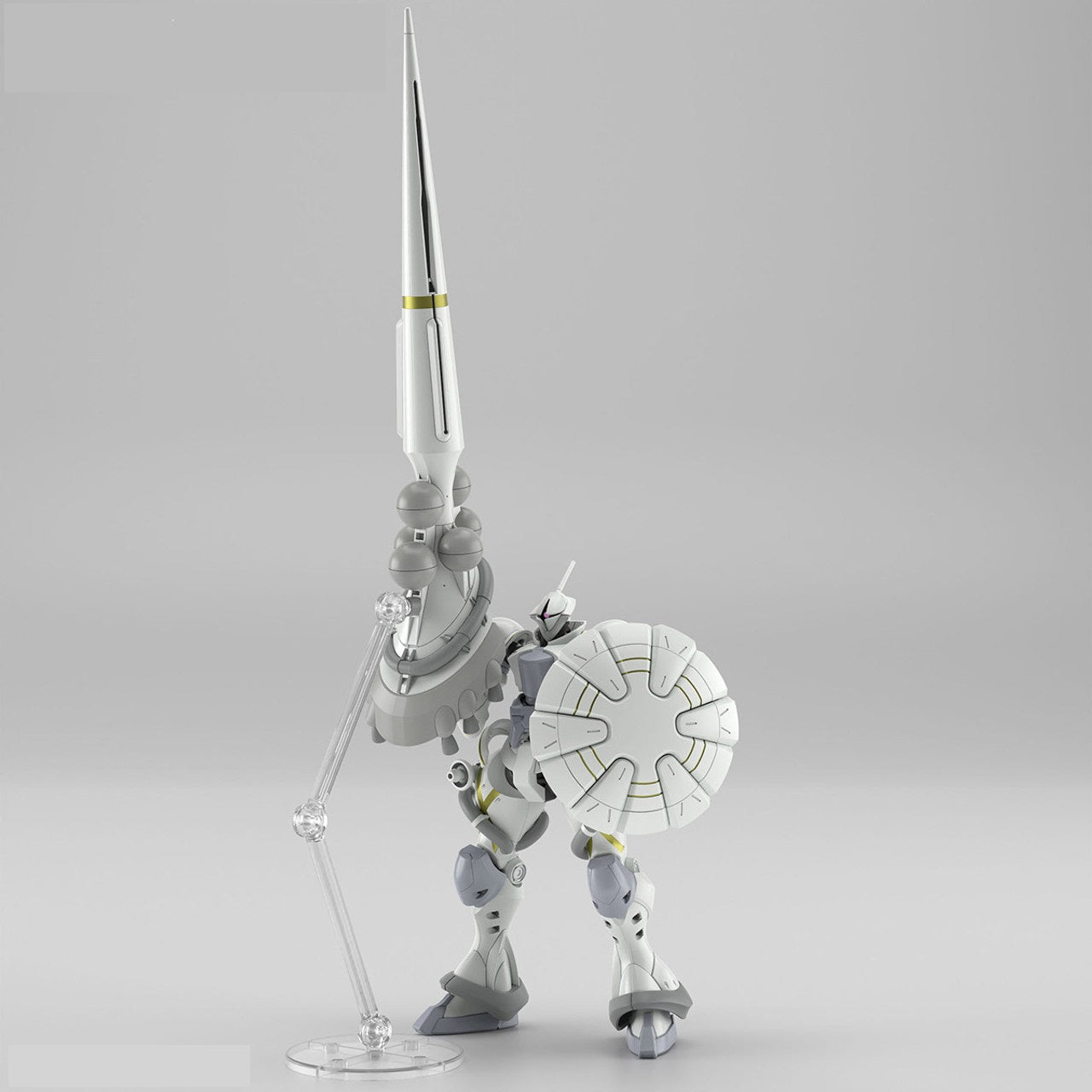White and grey robot model stands, holding a round shield, with a tall lance supported behind it by a clear stand