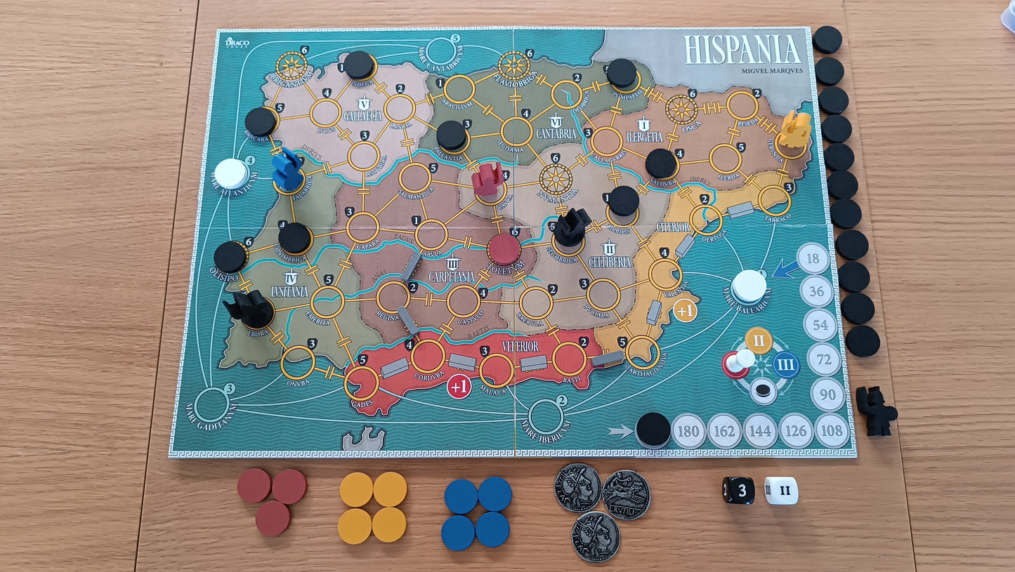 The 'Hispania' board game setup, featuring a map of ancient Iberia with player pieces, resource tokens, dice, and coins