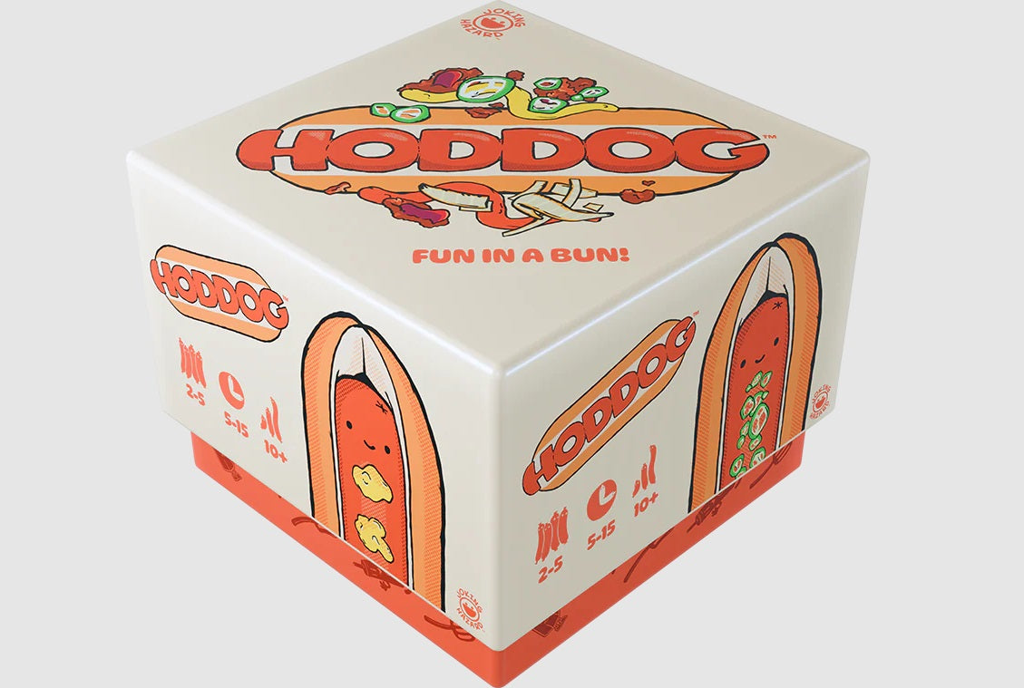 A cube-shaped game box for "HODDOG: Fun in a Bun!" in cream and orange, featuring cartoon hot dogs with toppings