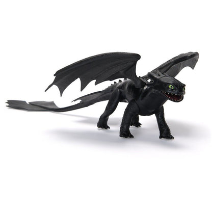 Black Toothless dragon toy with large wings, green eyes, and long tail, standing on a white background
