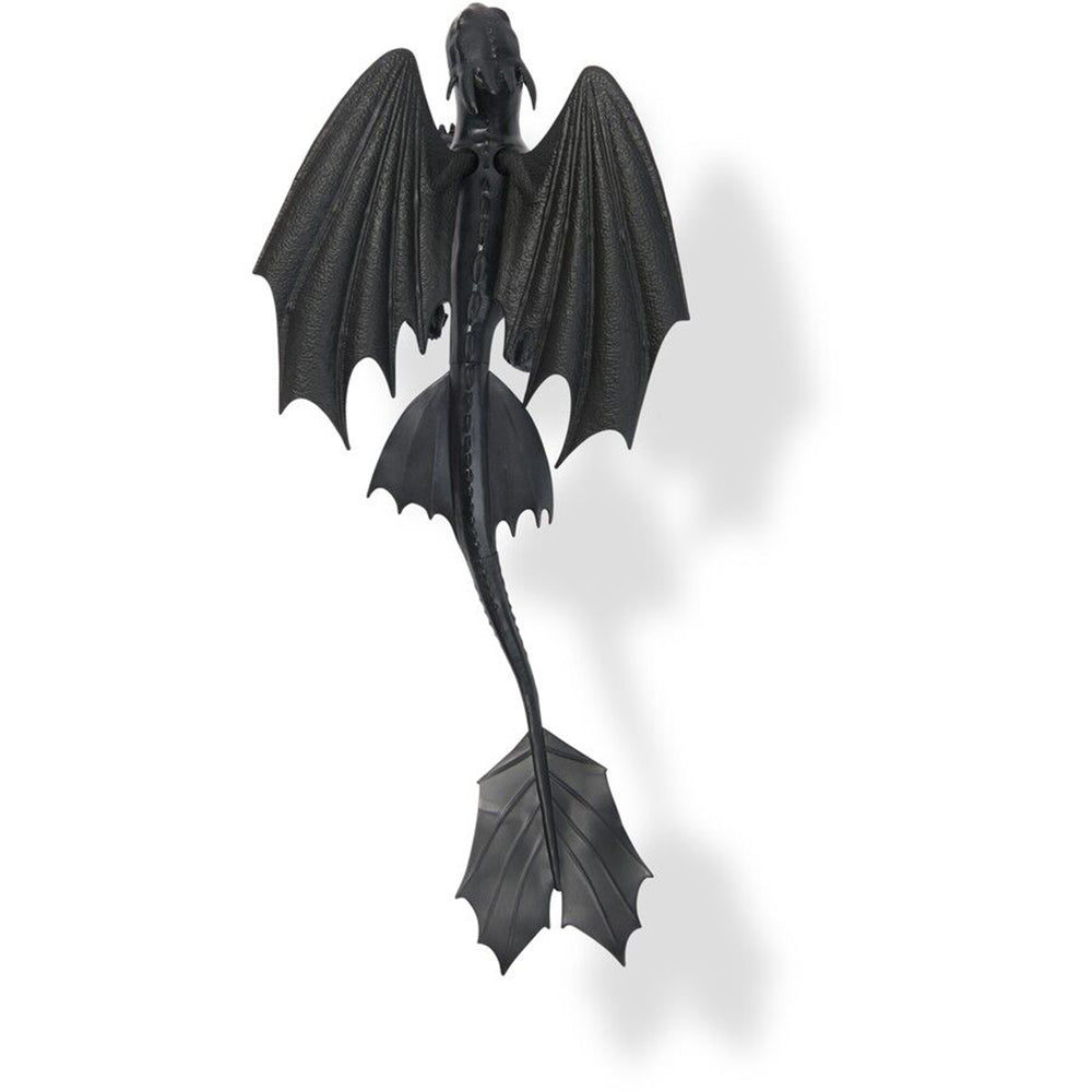 Toothless, the black Night Fury dragon from How to Train Your Dragon, seen from above with wide wings and long tail