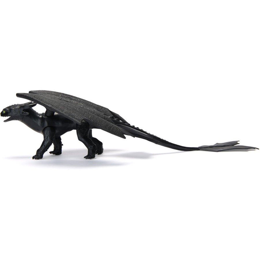 Black Toothless dragon action figure with prominent wings, green eyes, and a long tail, standing in profile on a white background