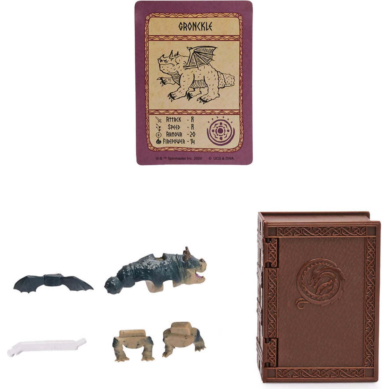Purple Gronckle dragon trading card, unassembled dragon toy figure parts, and a brown book-shaped container with a dragon carving