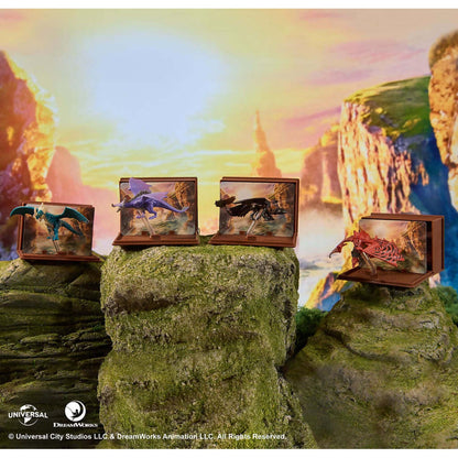 Four dragon figurines - blue, purple, black, red - in individual dioramas atop mossy cliffs against a vibrant sunset over mountains