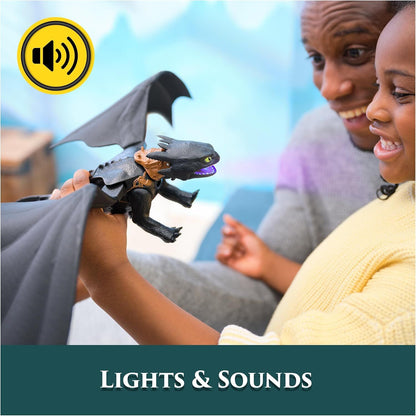 Child holds black Toothless dragon toy with glowing purple mouth, while a smiling adult and child look on, highlighting the toy's lights & sounds features