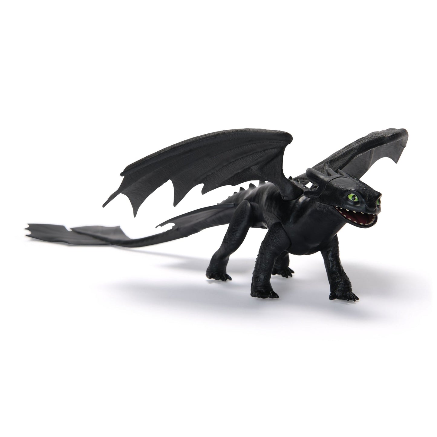 Black Toothless dragon toy with wide green eyes and an open mouth, standing on a white background