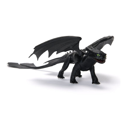 Black Toothless dragon toy with wide green eyes and an open mouth, standing on a white background