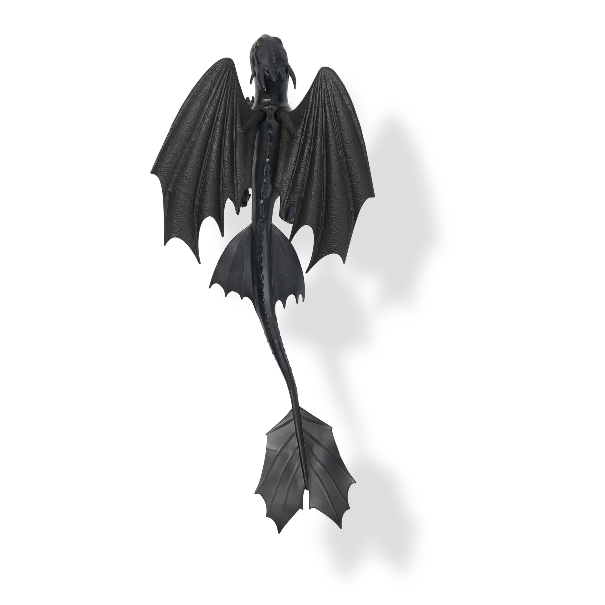 Toothless, the black Night Fury dragon from How to Train Your Dragon, seen from above with wide wings and long tail