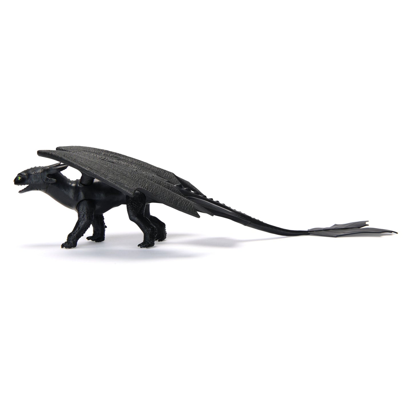 Black Toothless dragon action figure with prominent wings, green eyes, and a long tail, standing in profile on a white background