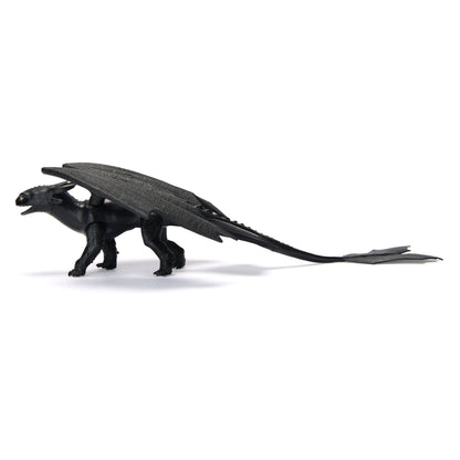 Black Toothless dragon action figure with prominent wings, green eyes, and a long tail, standing in profile on a white background