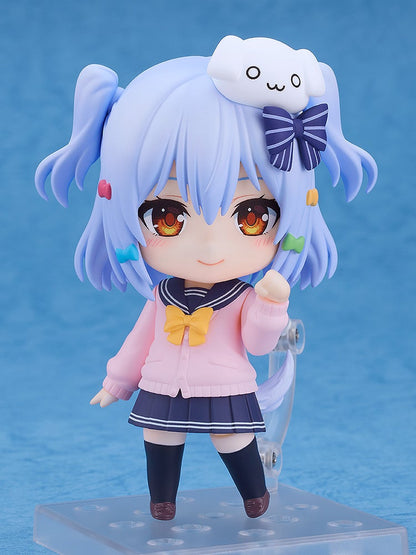 Nendoroid-style anime figure with light blue pigtails, 'owo' clip, pink cardigan, navy skirt, standing, smiling
