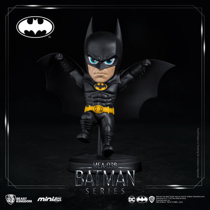 Batman figure holding gadget, displayed on black round base