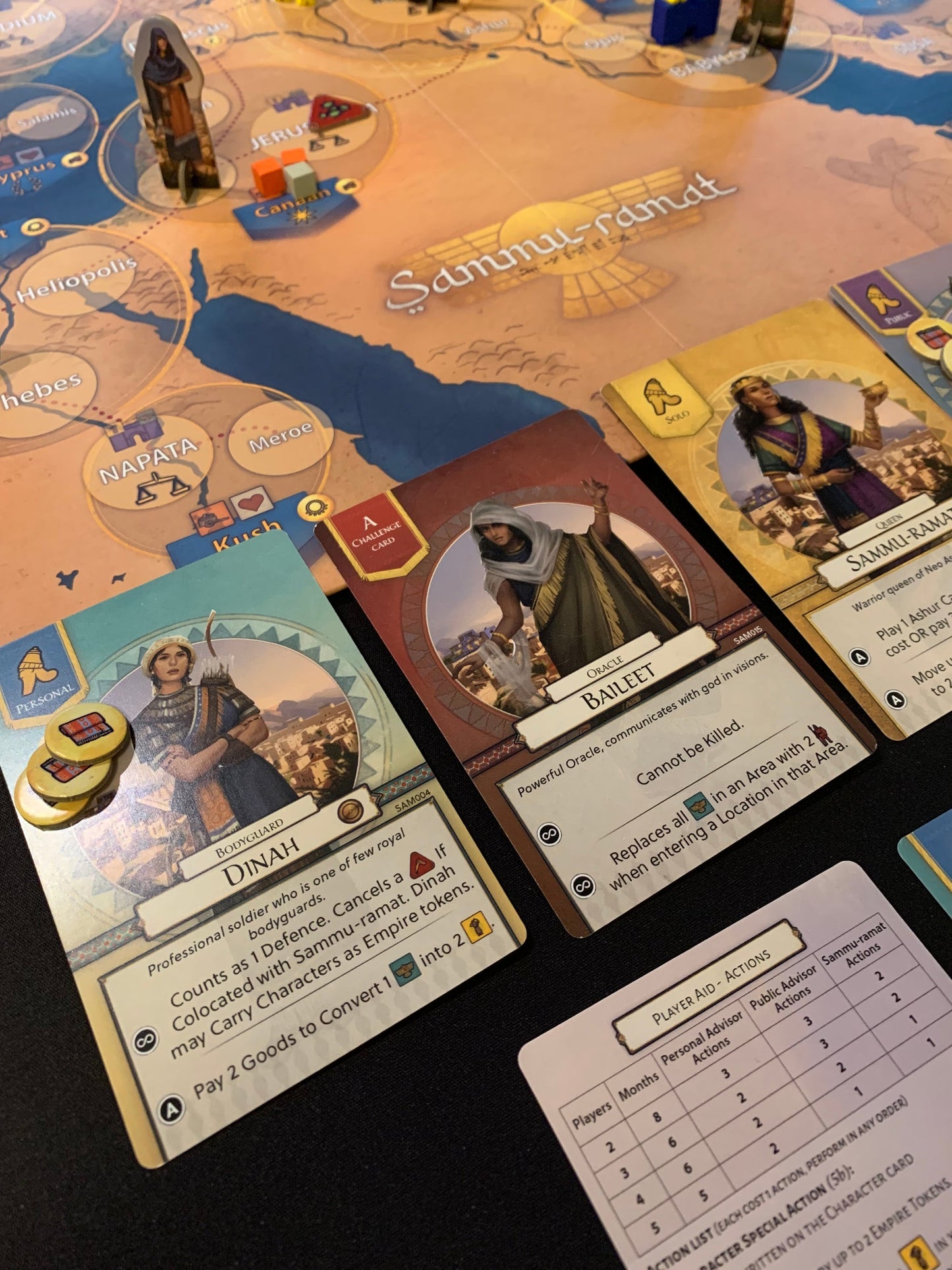 Board game with cards featuring character art coins and a player aid chart