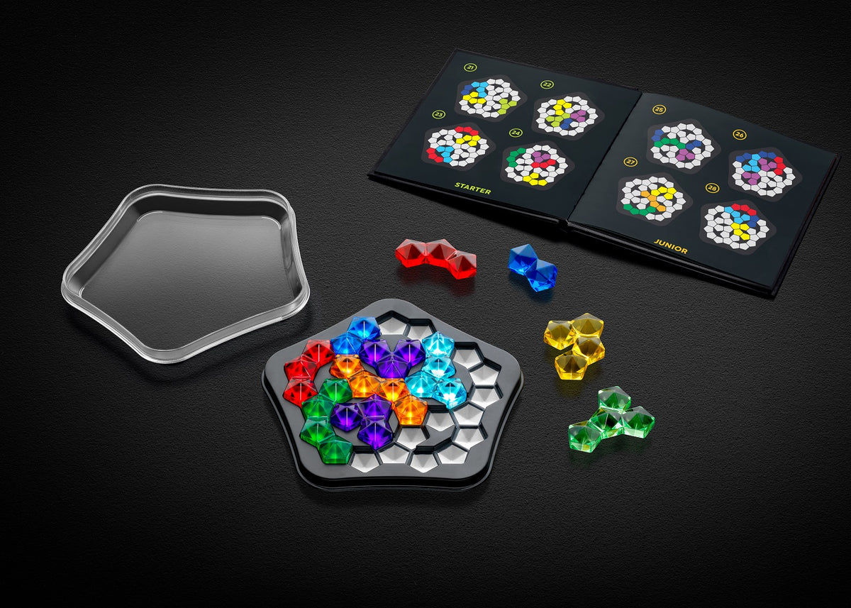Colorful IQ Deluxe Pentagon puzzle game pieces placed on a pentagonal board, next to an instruction booklet