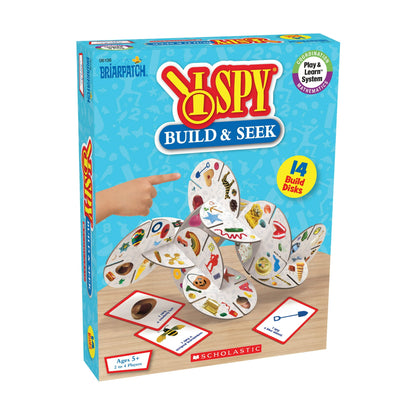 I SPY Build & Seek game box. A child's hand points to interconnected 'Build Disks' covered in hidden items, plus 'I Spy' cards