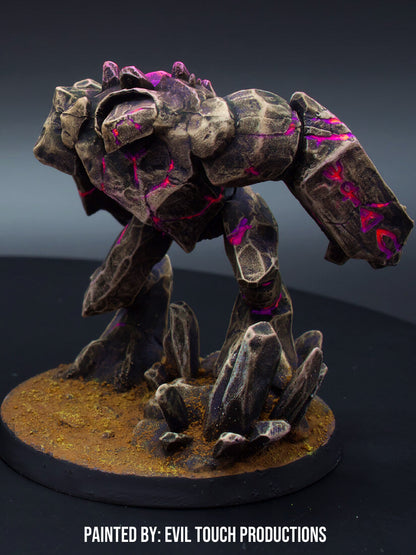 A dark stone golem miniature with bright pink glowing cracks stands on a rocky base