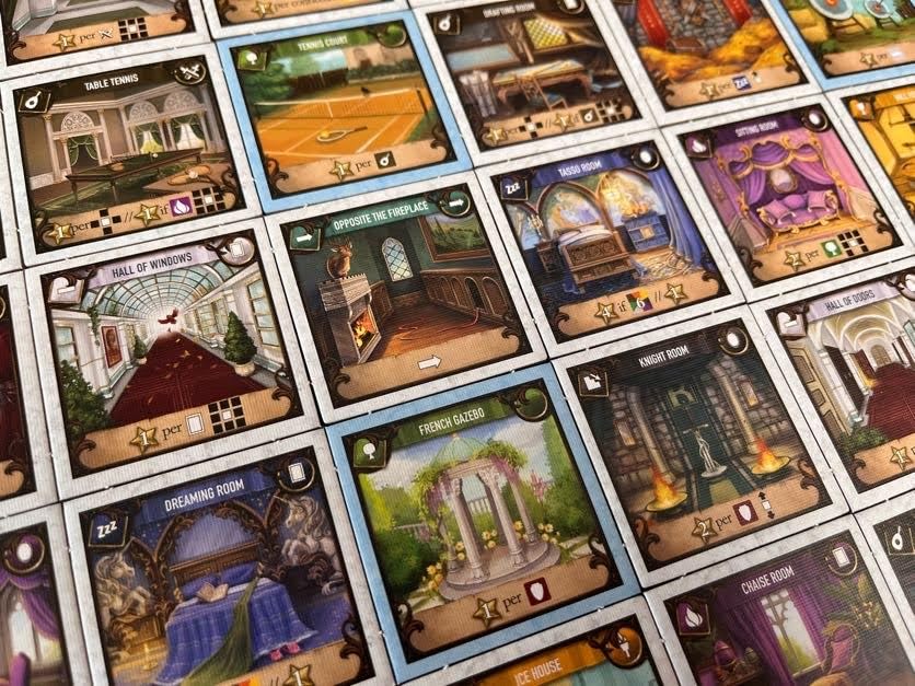 Close up of cards for the board game Mansions of Madness showing various rooms and locations like a tennis court hall of windows and dreaming room