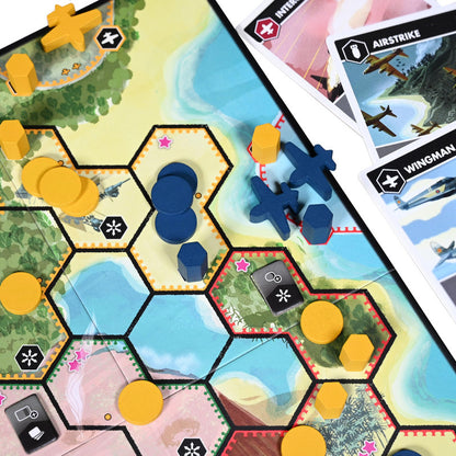 Overhead view of a board game featuring hexagonal tiles with tropical terrain wooden tokens and game cards depicting aircraft