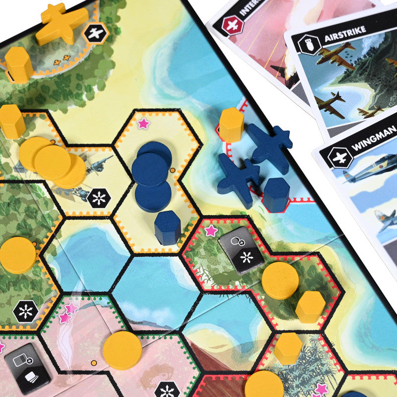 Overhead view of a board game featuring hexagonal tiles with tropical terrain wooden tokens and game cards depicting aircraft