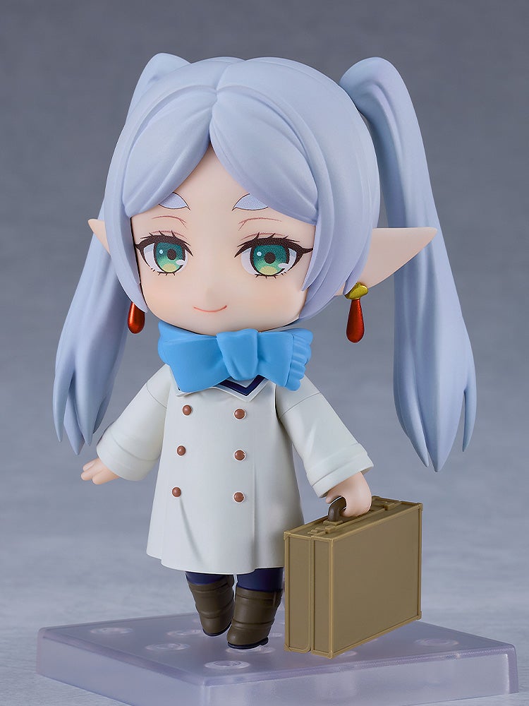 Good Smile Company Nendoroid Frieren in winter clothes featuring a blue scarf white double-breasted coat brown boots and carrying a small suitcase