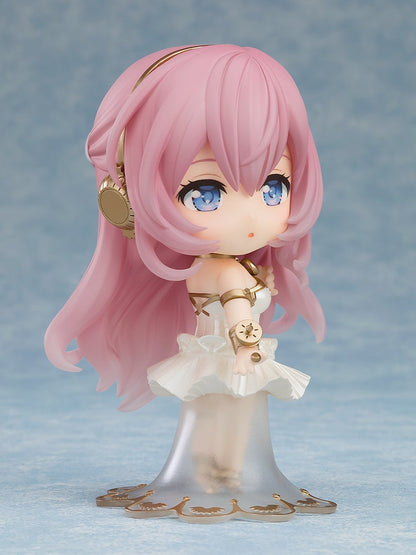 Chibi Megurine Luka figure with pink hair, blue eyes, gold headphones, wearing a white translucent gown, looking surprised