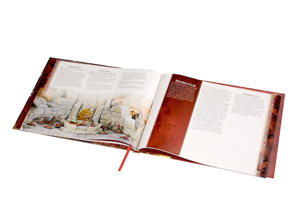 Open hardcover fantasy game rulebook displaying an illustration of miniature figures and a page titled 'Momentum'